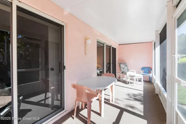 a dining room with furniture and a floor to ceiling window