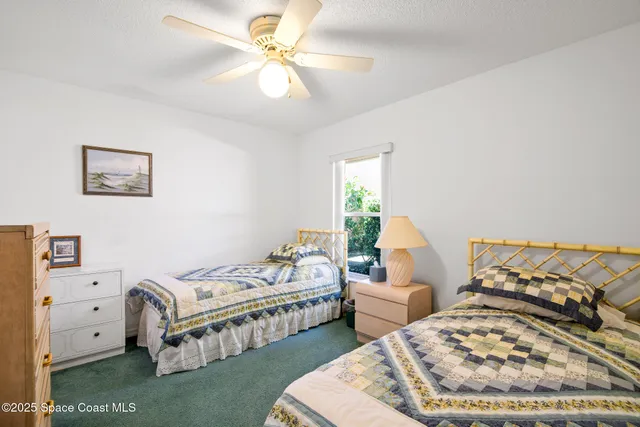 a bedroom with two beds and a chandelier