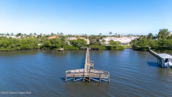 a table and chairs sitting in a wooden deck next to a lake