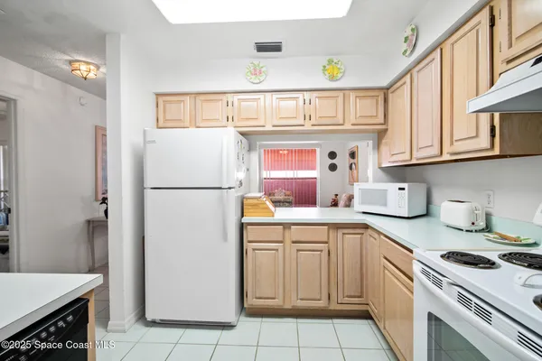 a kitchen with a sink a refrigerator and cabinets