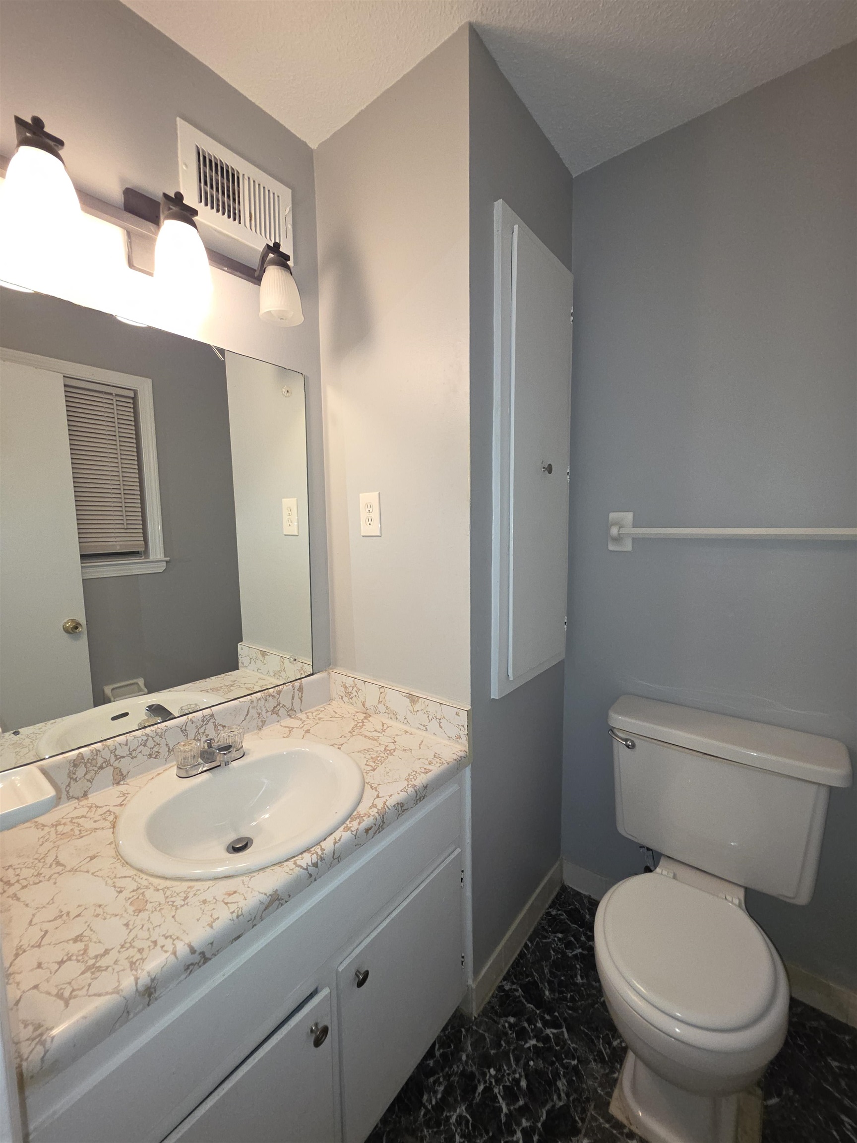 936 Chesterton Drive Memphis, TN 38127 - Photo 24 of 28 a bathroom with a granite countertop toilet a sink and a mirror