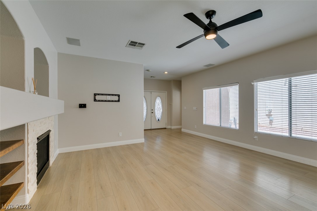 8909 Houston Ridge Avenue Las Vegas, NV 89178 - Photo 9 of 45 A well-lit living space with light-toned hardwood flooring and a charming fireplace.