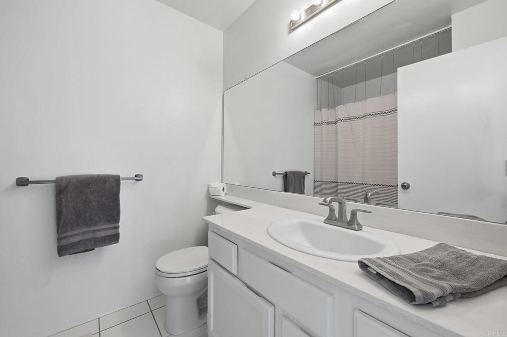 2972 Lancaster Road Carlsbad, CA 92010 - Photo 19 of 36 a bathroom with a granite countertop sink a toilet and mirror