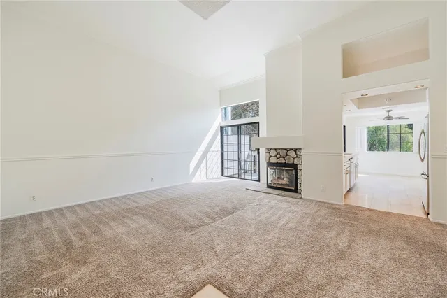 a view of an empty room with a fireplace and a large window
