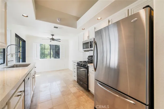 a kitchen with granite countertop white cabinets and a window