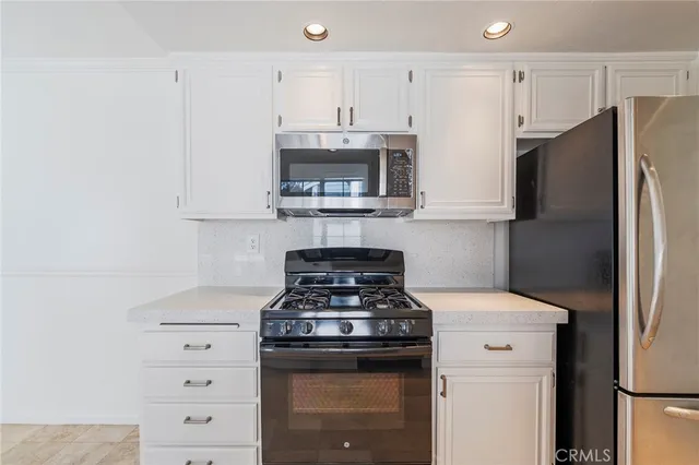 a large kitchen with stainless steel appliances granite countertop a stove and a sink