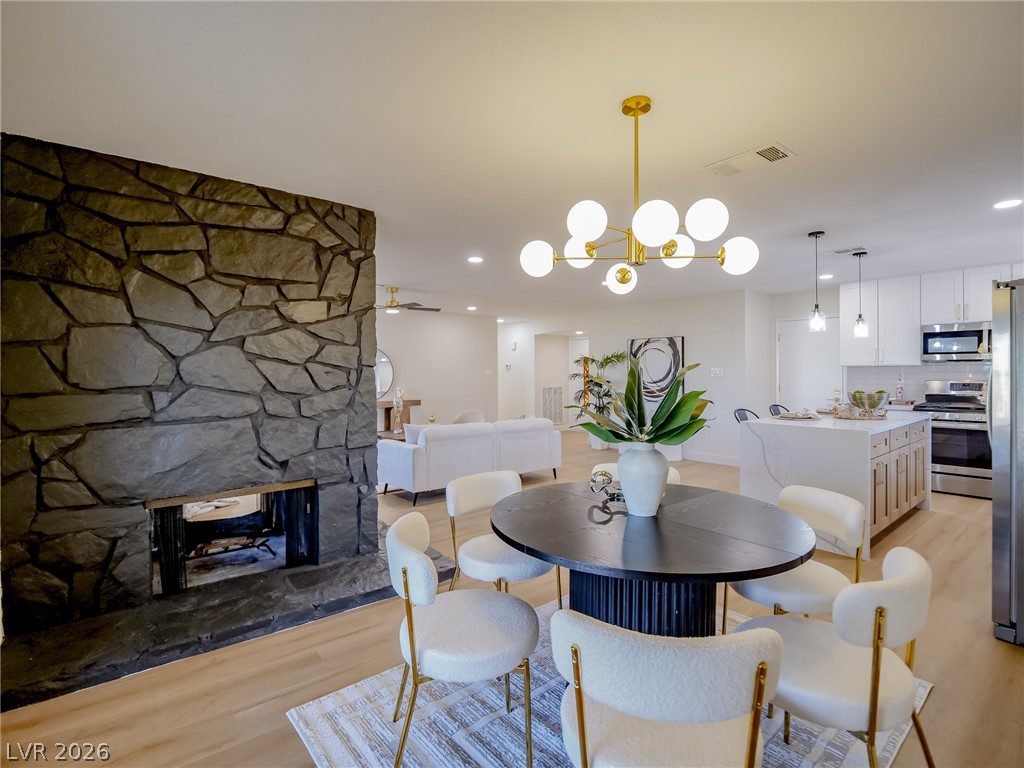 321 Lakehurst Road Las Vegas, NV 89145 - Photo 13 of 33 The dining area sits beside the two-way stone fireplace, open to both the kitchen and living room.