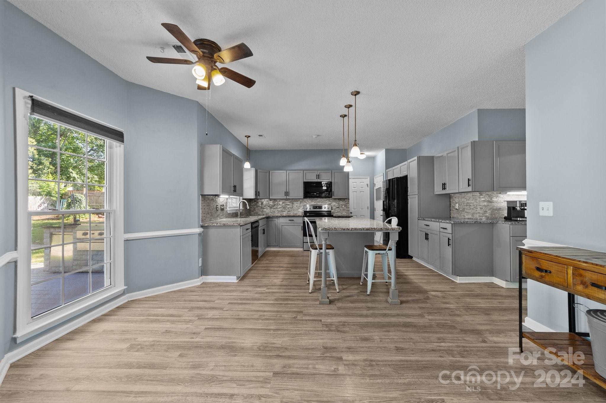 1041 Fairway Ridge Drive Northwest Concord, NC 28027 - Photo 14 of 44 a kitchen with stainless steel appliances kitchen island granite countertop a table chairs and a chandelier