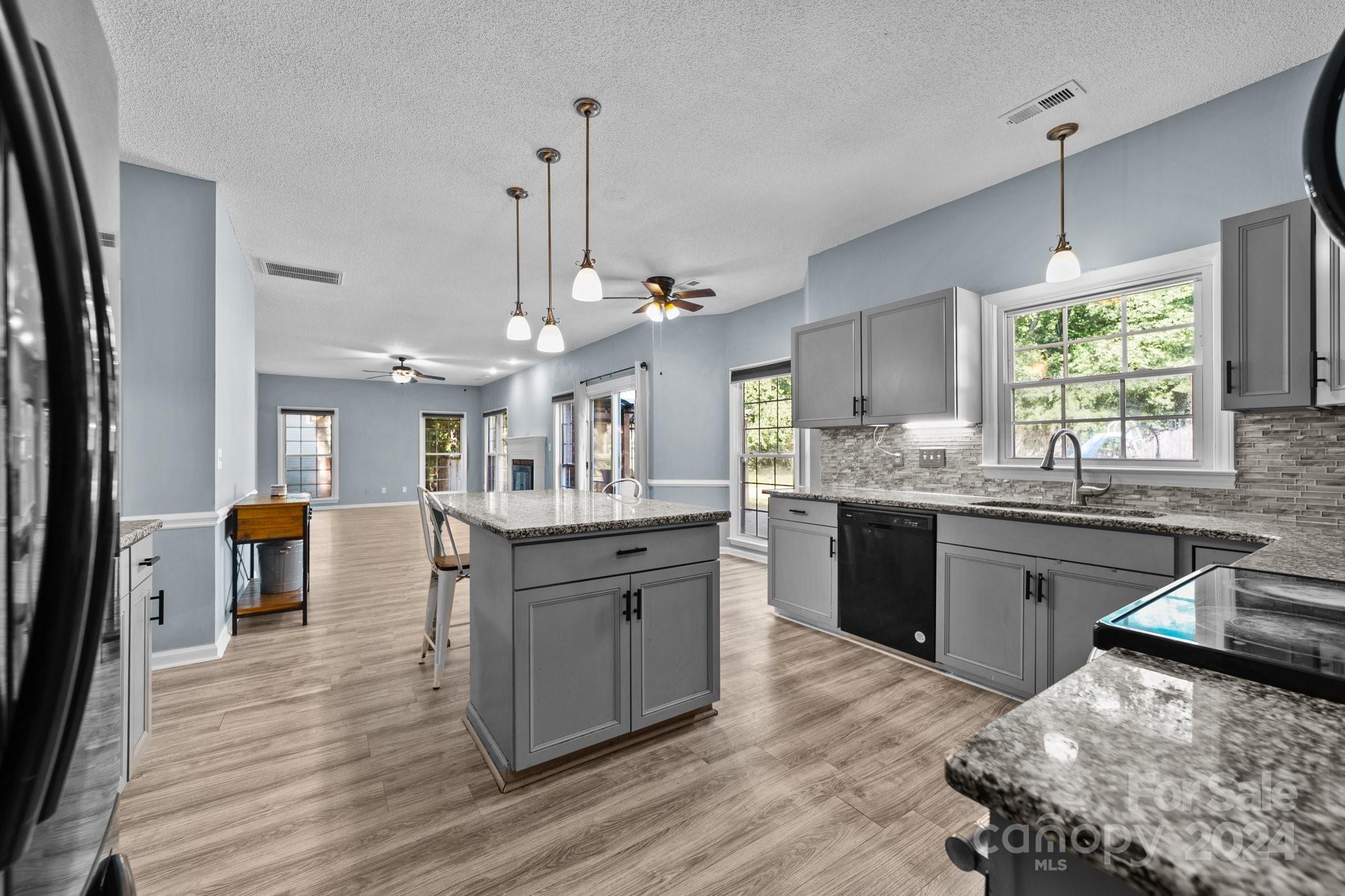 1041 Fairway Ridge Drive Northwest Concord, NC 28027 - Photo 19 of 44 a kitchen with stainless steel appliances granite countertop a refrigerator a sink dishwasher a stove and white countertops with wooden floor