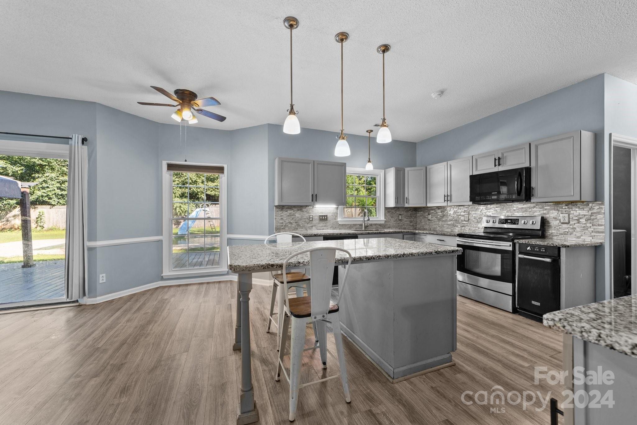 1041 Fairway Ridge Drive Northwest Concord, NC 28027 - Photo 20 of 44 a kitchen with kitchen island granite countertop a stove a sink a center island a counter space and a window
