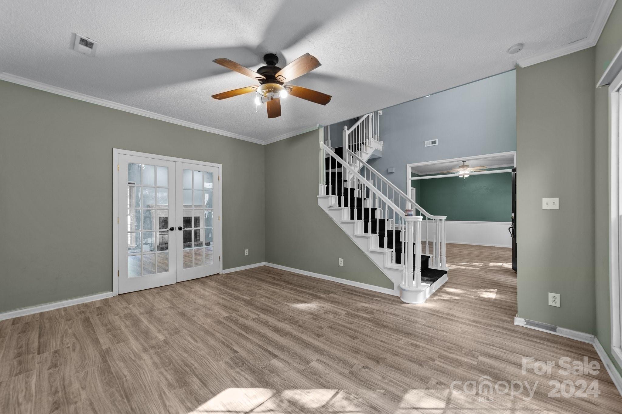 1041 Fairway Ridge Drive Northwest Concord, NC 28027 - Photo 5 of 44 a view of an empty room with wooden floor and a ceiling fan