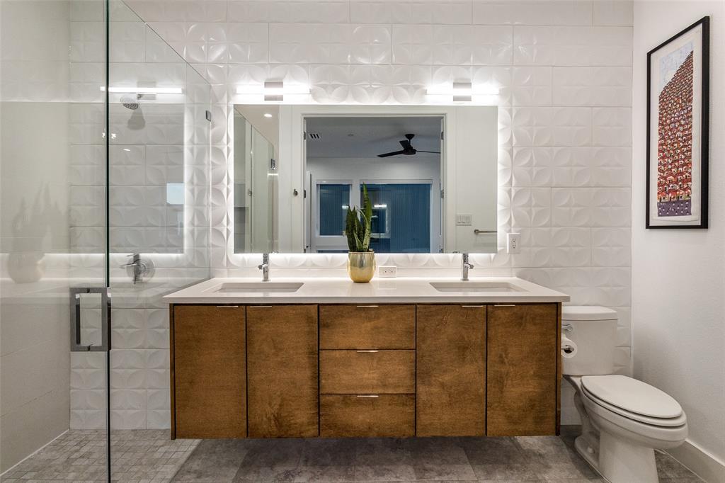 4805 Manett Street, Unit 101 Dallas, TX 75204 - Photo 13 of 18 a bathroom with a granite countertop sink a toilet and a mirror