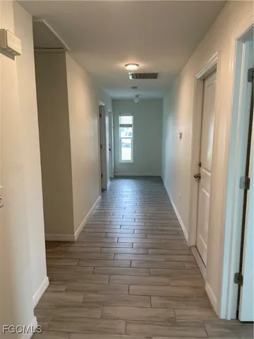 a view of a hallway with wooden floor