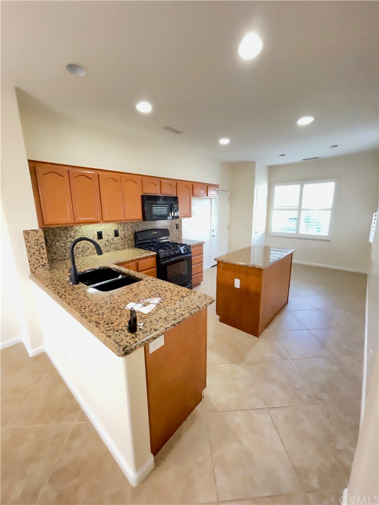 24042 Boulder Oaks Drive Corona, CA 92883 - Photo 7 of 8 a kitchen with stainless steel appliances granite countertop a stove and a refrigerator