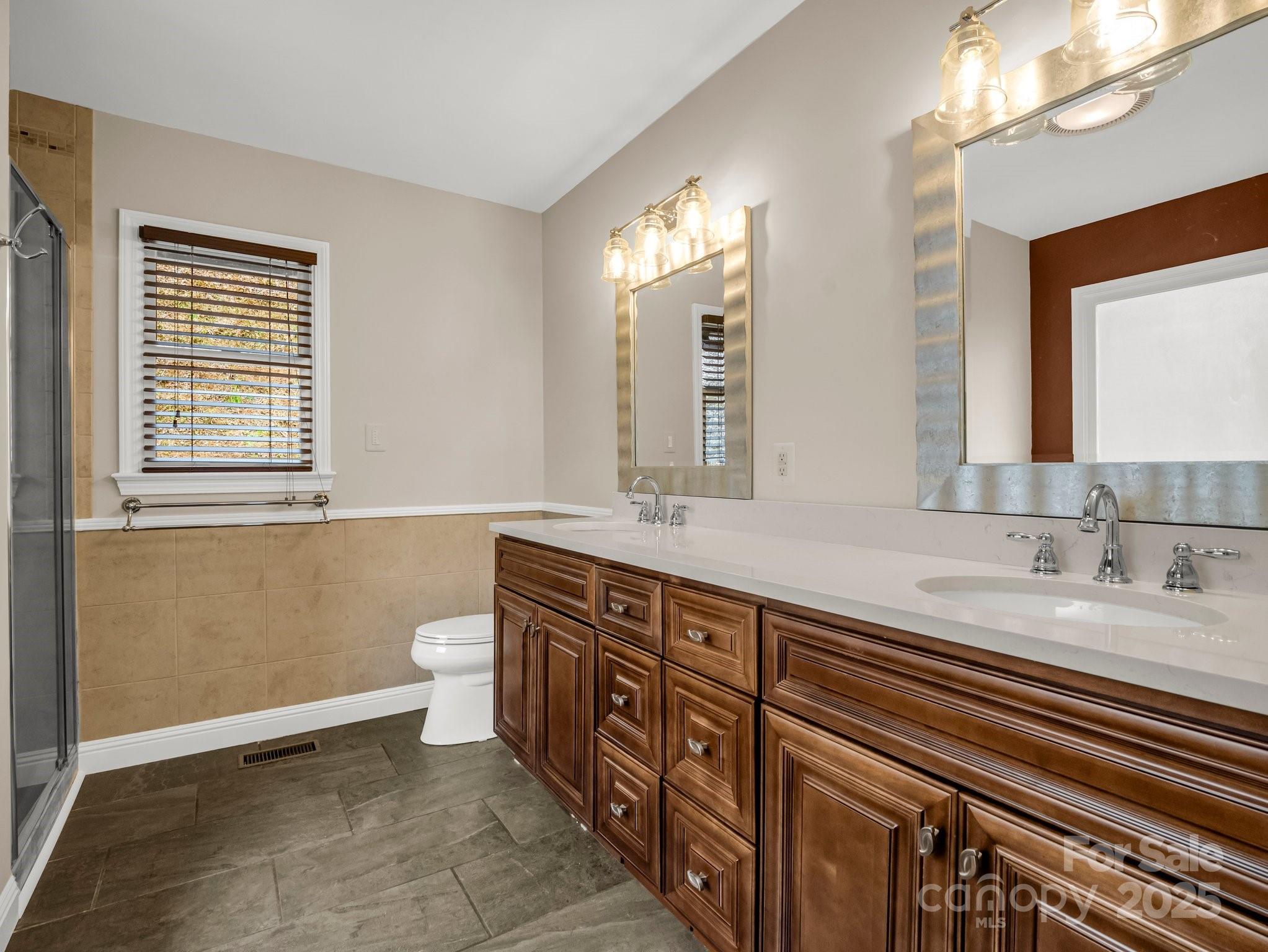 1116 High Vista Drive Mills River, NC 28759 - Photo 20 of 40 a spacious bathroom with a double vanity sink a mirror and a toilet