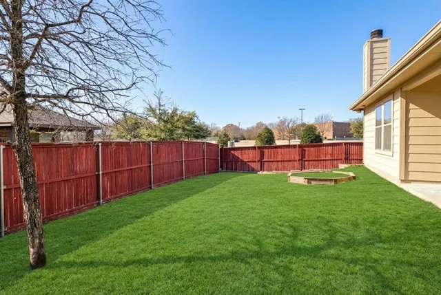 a view of backyard with wooden fence