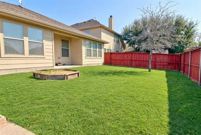 a backyard of a house with table and chairs