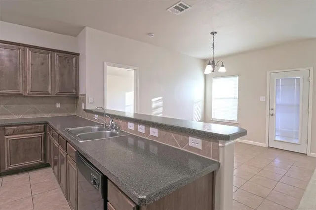 a kitchen with stainless steel appliances granite countertop a sink window and cabinets
