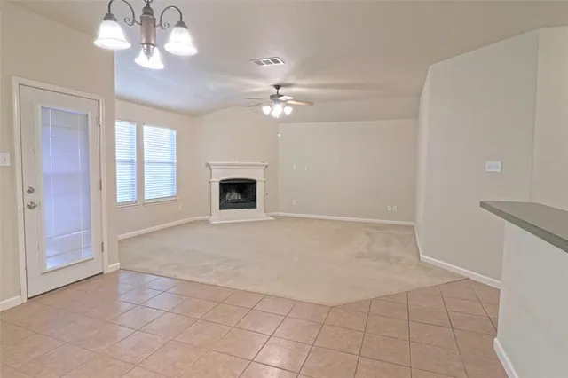 an empty room with windows and fireplace