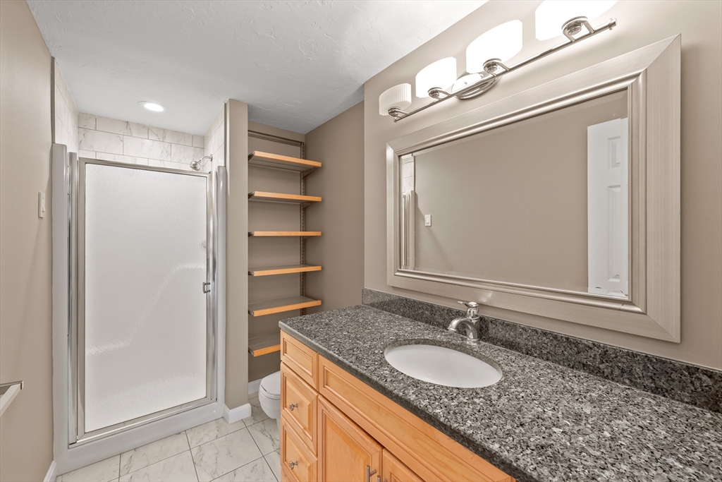 48 Pointe Rok Drive, Unit 48 Worcester, MA 01604 - Photo 23 of 42 a bathroom with a granite countertop sink and a mirror