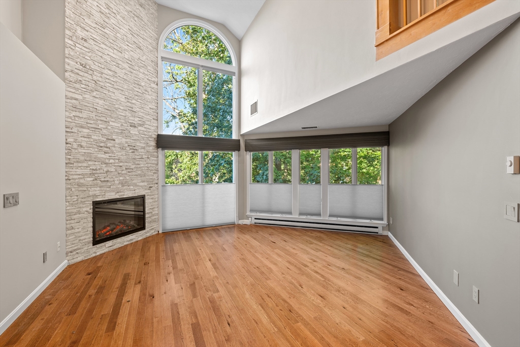 48 Pointe Rok Drive, Unit 48 Worcester, MA 01604 - Photo 9 of 42 an empty room with wooden floor a fireplace and windows