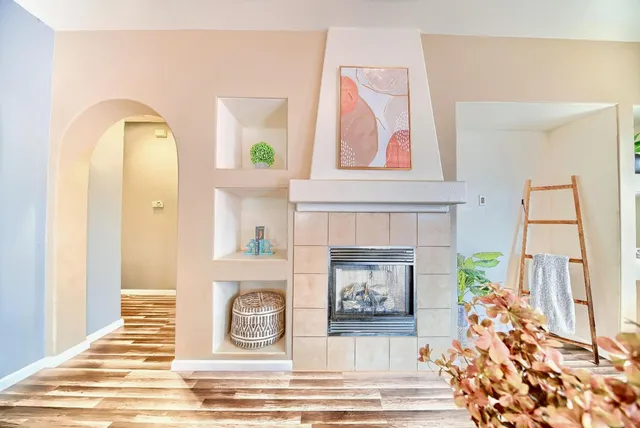 a view of a livingroom with wooden floor and a fireplace