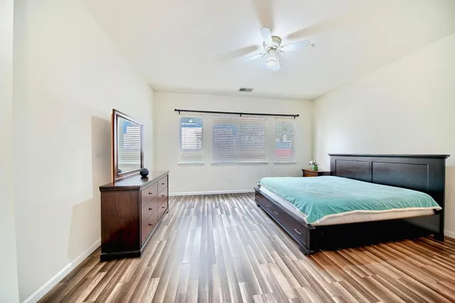 a bedroom with a bed and wooden floor
