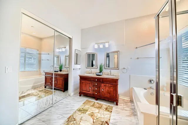 a spacious bathroom with a tub sink and mirror