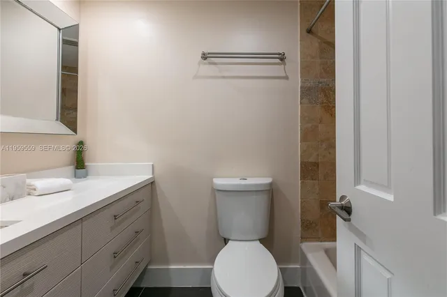 a bathroom with a granite countertop toilet sink and a mirror