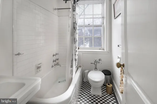 a bathroom with a bathtub sink toilet and a rug