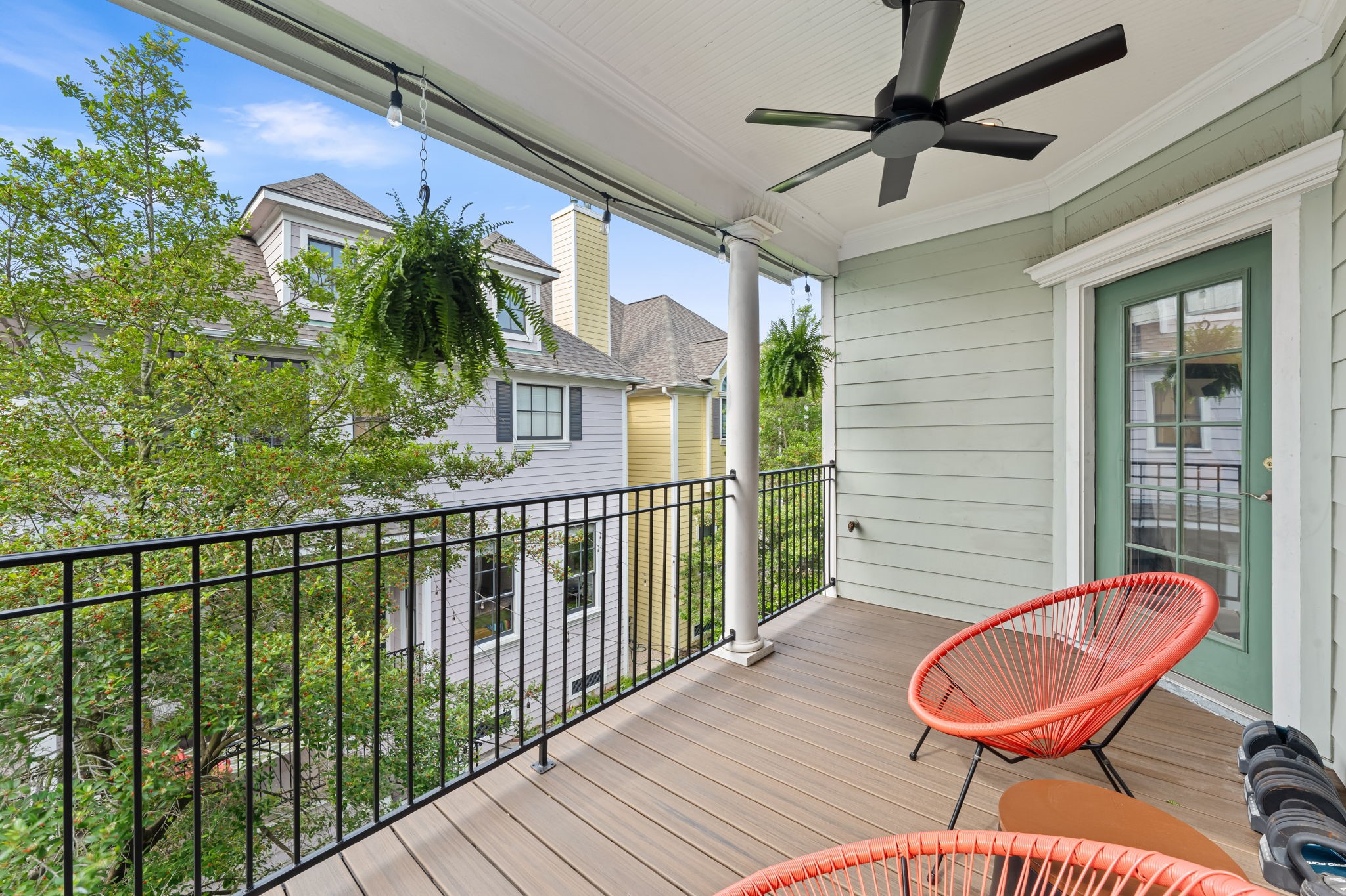 520 Oxford Street, Unit F Houston, TX 77007 - Photo 25 of 38 The private covered balcony off the primary bedroom offers peaceful treetop views and is outfitted with a ceiling fan and string lights, creating an ideal outdoor retreat for morning coffee or evening unwinding. The covered design and mature canopy provide shade and privacy in this elevated outdoor living space.