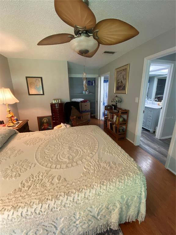 1609 Whitebridge Drive, Unit C Palm Harbor, FL 34684 - Photo 19 of 30 a bed room with a bed mirror and a chandelier