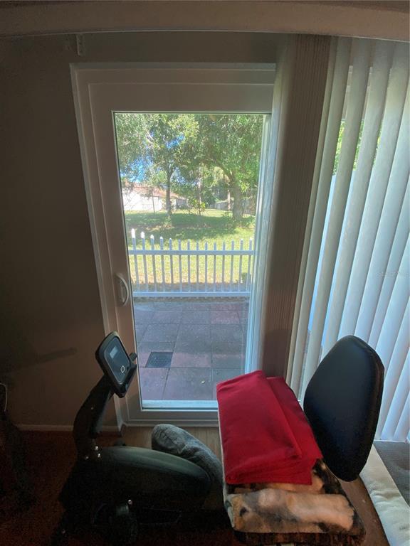 1609 Whitebridge Drive, Unit C Palm Harbor, FL 34684 - Photo 21 of 30 a living room with furniture and a floor to ceiling window