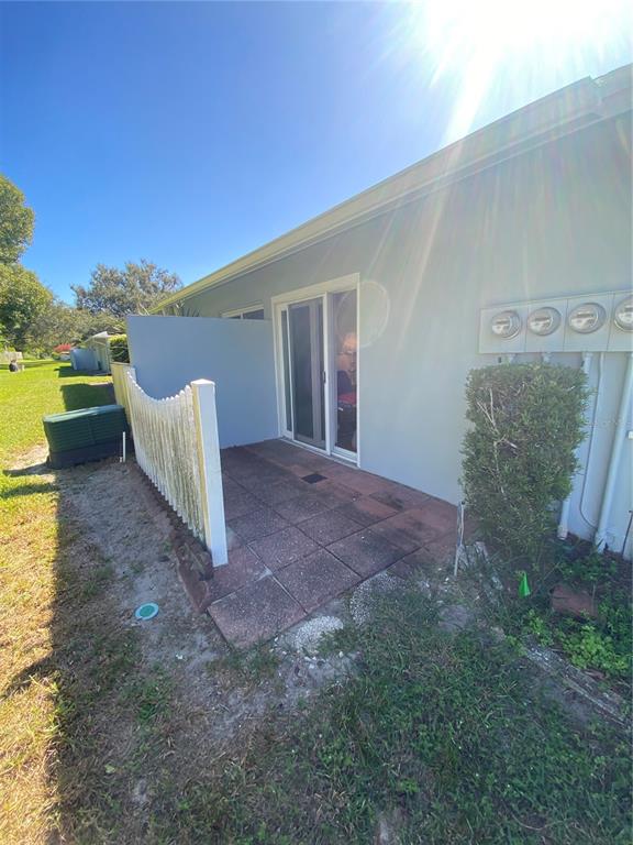1609 Whitebridge Drive, Unit C Palm Harbor, FL 34684 - Photo 23 of 30 a view of a patio with furniture and a yard