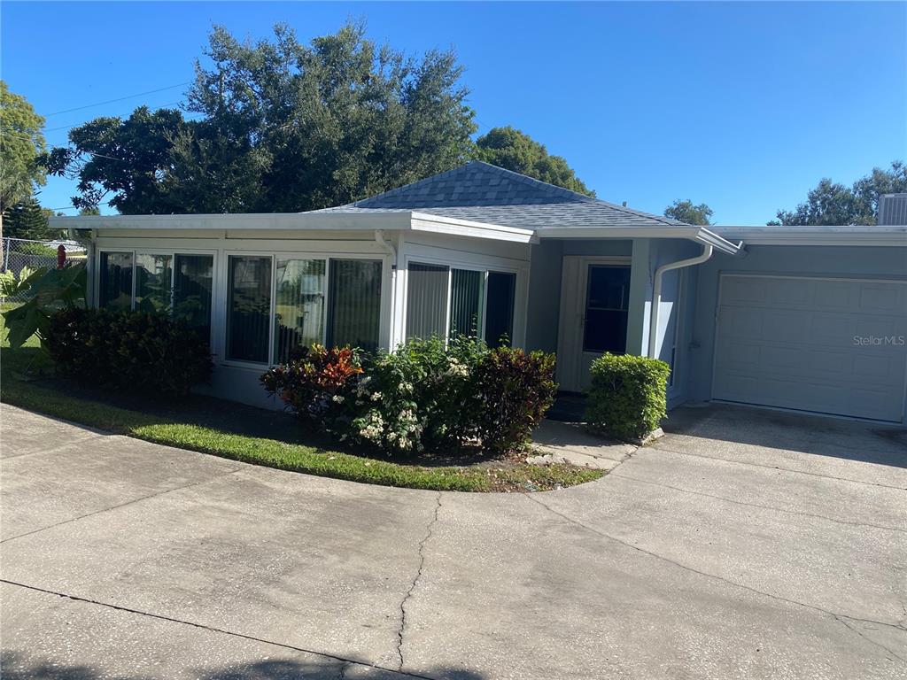 1609 Whitebridge Drive, Unit C Palm Harbor, FL 34684 - Photo 26 of 30 a view of a house with potted plants and a table and chairs