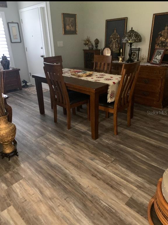 1609 Whitebridge Drive, Unit C Palm Harbor, FL 34684 - Photo 9 of 30 a view of a dining room with furniture and wooden floor
