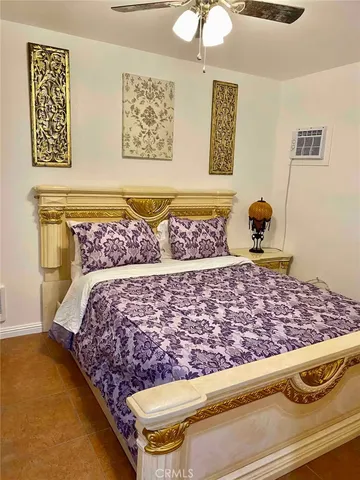 a bedroom with a bed painting on wall and a window