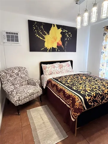 a bed sitting in a bedroom next to a window with a rug