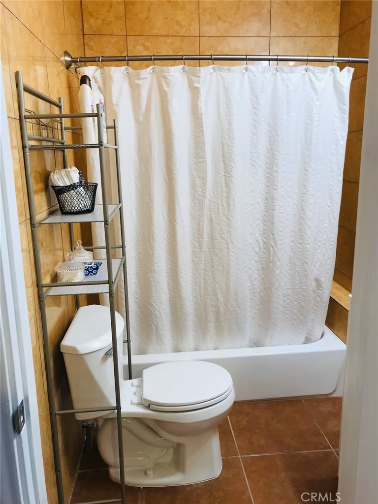 1364 East 61st Street Los Angeles, CA 90001 - Photo 23 of 32 a bathroom with a toilet and a shower curtain
