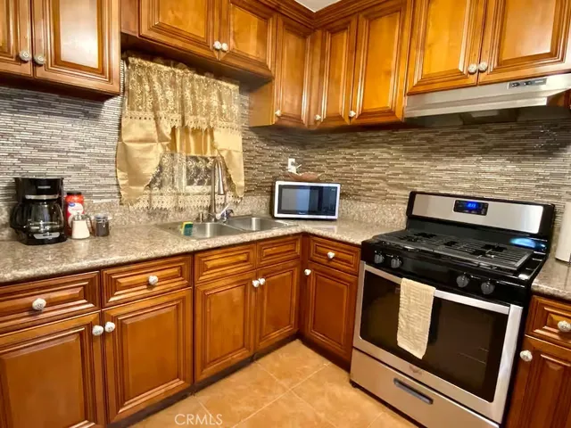 a kitchen with granite countertop a refrigerator and a stove top oven