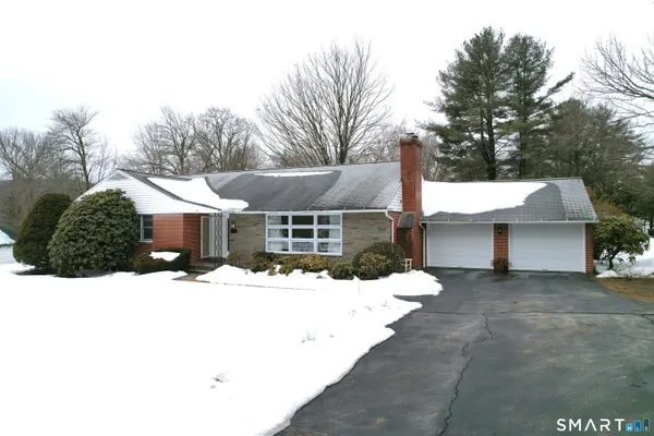 a front view of a house with a yard covered in snow