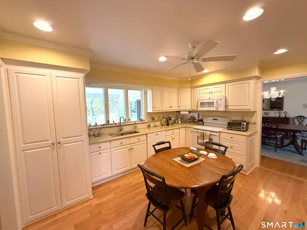 a kitchen with a table chairs refrigerator and cabinets