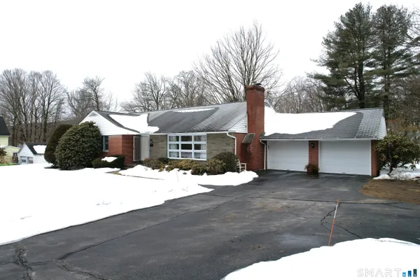 a front view of a house with a yard covered in snow