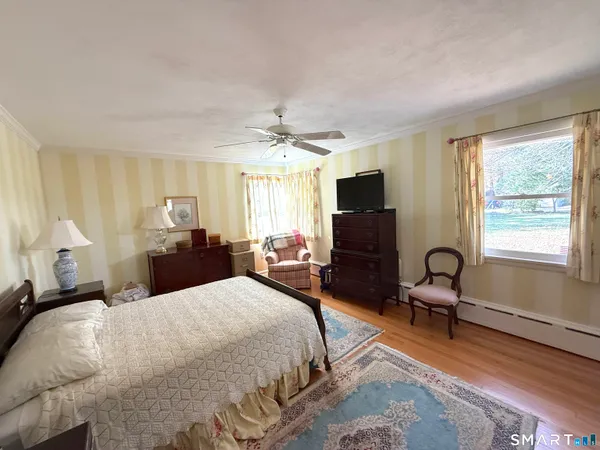 a bedroom with a bed flat screen tv and windows