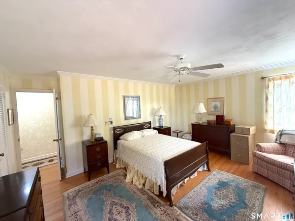 a spacious bedroom with a bed and wooden floor