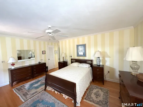 a large bedroom with a bed and wooden floor