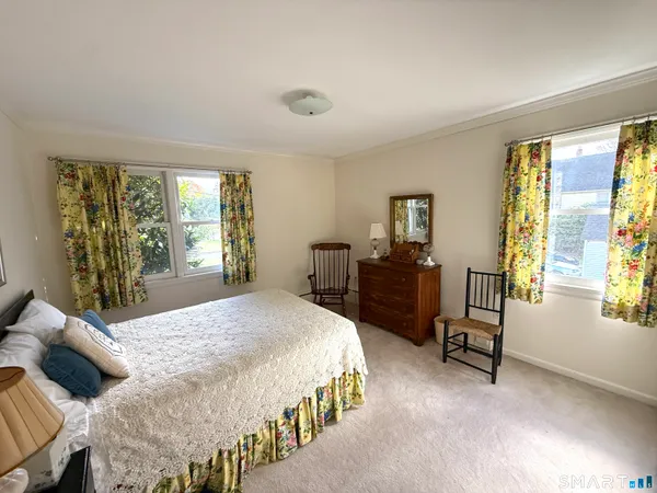 a bedroom with a bed and large windows