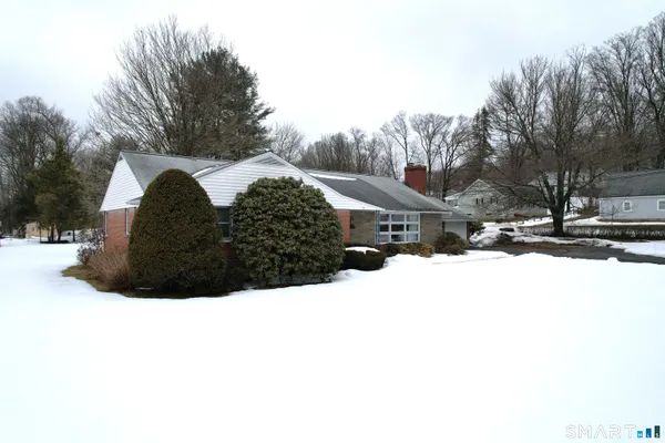 a view of large house with a yard covered in snow