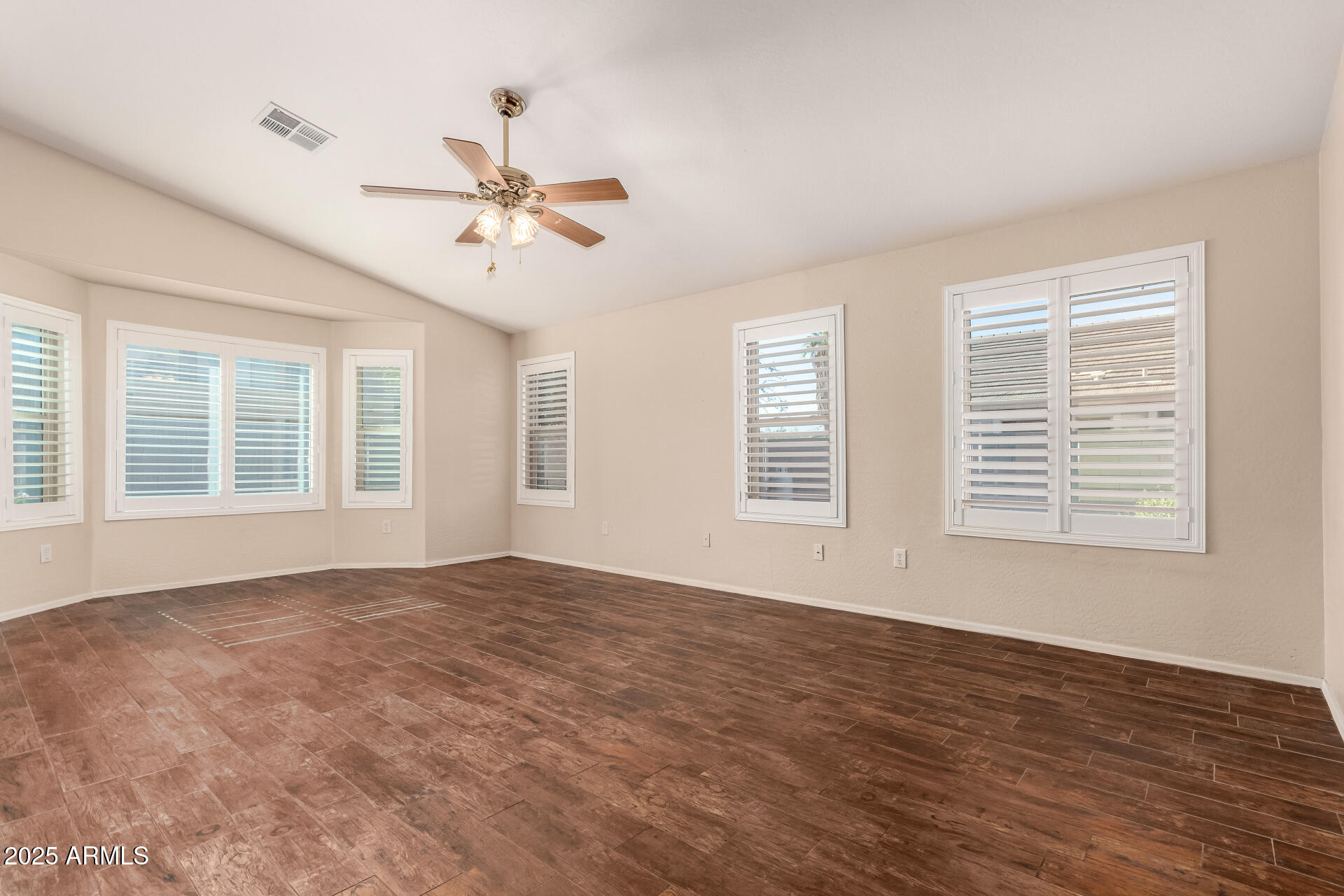 2513 West Carter Road Phoenix, AZ 85041 - Photo 14 of 27 a view of an empty room with a window and a ceiling fan