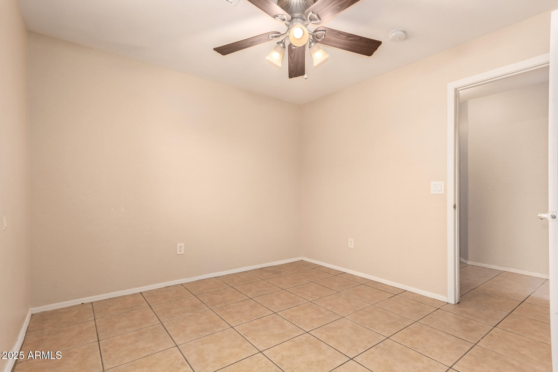 2513 West Carter Road Phoenix, AZ 85041 - Photo 19 of 27 an empty room with a chandelier fan and kitchen view